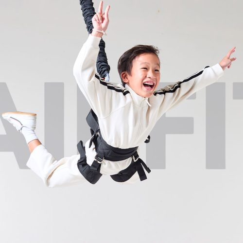 Happy child enjoying bungee fitness training designed for kids suspension workout program